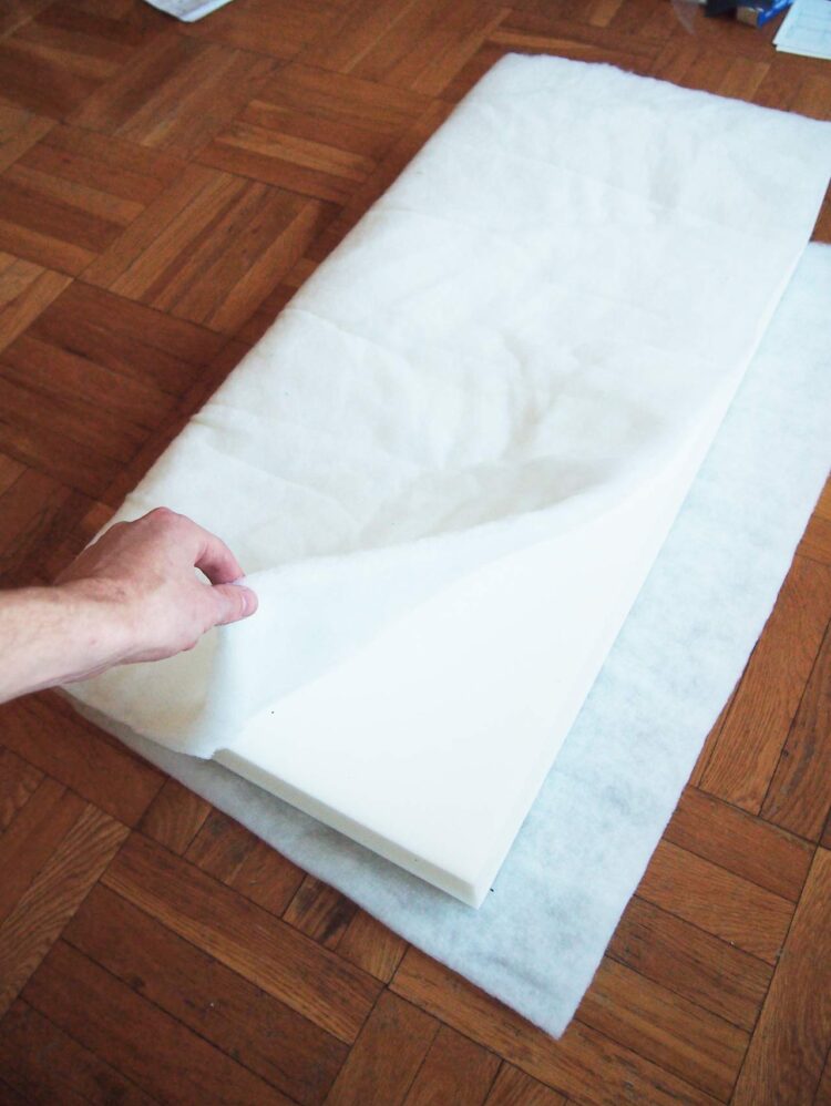 21     Cut out pieces of batting that wrap fully around the length of the foam cushions, as pictured. The batting should not cover much, if any, of the shorter sides of the cushion, as pictured.