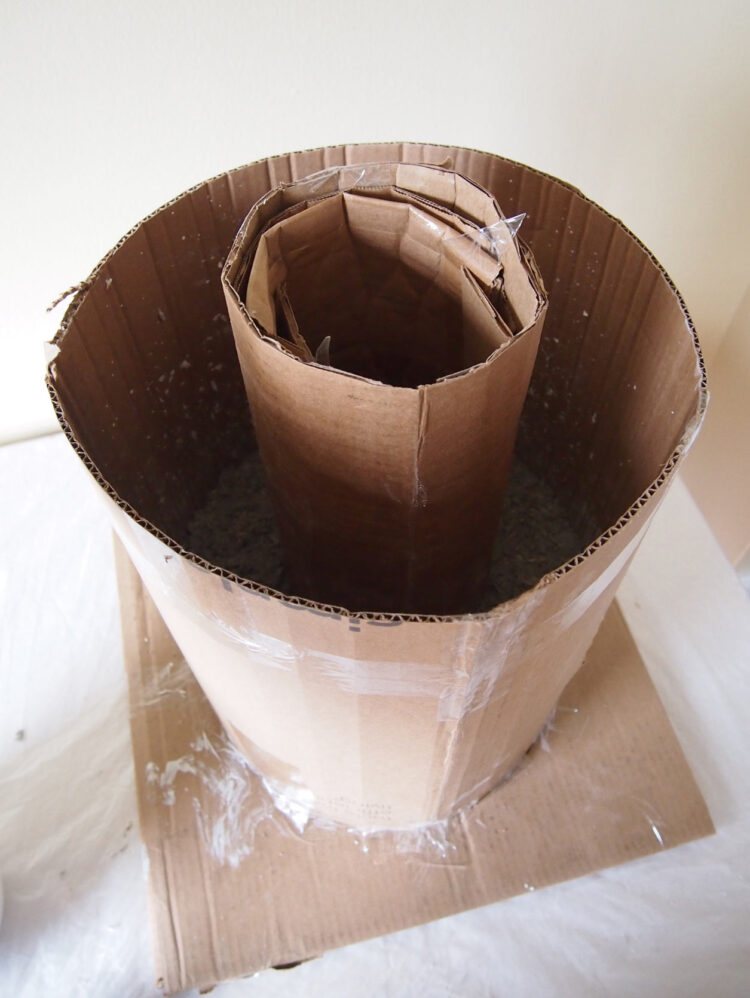 9     Place a smaller cardboard cylinder, about 6in (16cm) in diameter, in the center of the larger one.