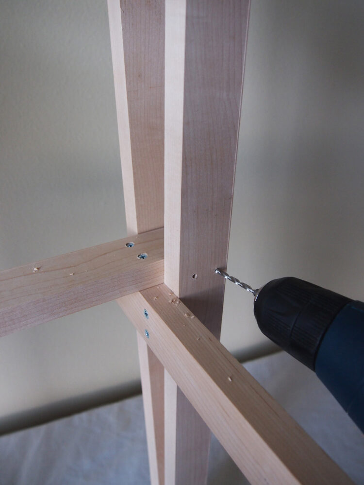 22     Drill holes, countersink, and add two screws to the vertical 27.5in (70cm) piece, securing it to the 20in (50cm) piece. Repeat in 3 other locations to secure the frame.