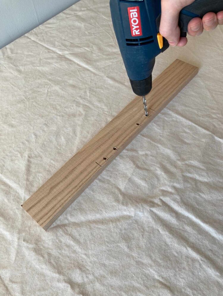 12     Drill pilot holes, then 1/4in holes exactly where the dowel pins lined up. The holes should only be 1/2in (1.5cm) deep. If you turn twist the drill bit around in the hole after drilling to your depth, you'll make a more generous opening for the dowel pins.