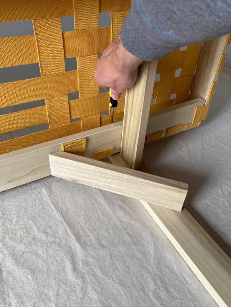 35     Attach the frame to the legs, and continue applying horizontal webbing until the bed is done. Make sure to measure out your spacing in advance.
